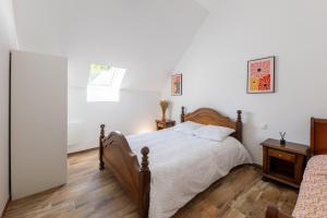 a bedroom with a wooden bed and a window at Charme nature et grand espace in Saint-Setiers
