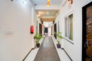 a corridor of a building with potted plants at Super Townhouse Vasundra Nagar Formerly Joystel in Jaipur