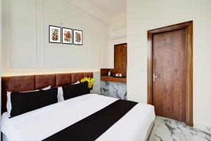 a bedroom with a large bed and a wooden door at Super Collection O Surajpur Chowk Greater Noida in Noida