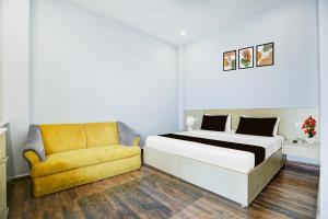 a bedroom with a bed and a yellow chair at Super Collection O Phagwara Near LPU Law Gate in Phagwāra