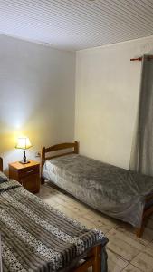 a bedroom with two beds and a lamp on a table at San vicente misiones in San Vicente
