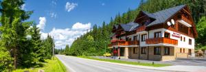 een groot huis aan de kant van een weg bij Apartmány Tri Studničky in Demanovska Dolina