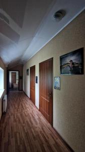 an empty room with a hallway with wood floors and a wall at Ночівля in Poltava