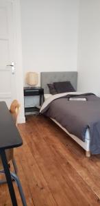 アミアンにあるBel appartement 2 chambres proche St Leuのベッドと木の床のある寝室