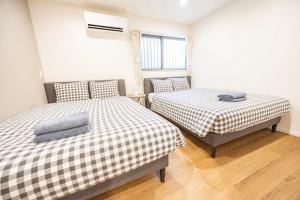 una habitación con dos camas y una ventana en Hiro Yanaka hotel, en Tokio