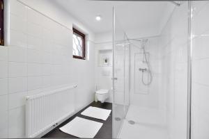 a white bathroom with a shower and a toilet at Vila Laura in Bled