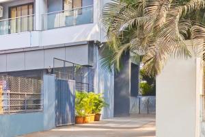 a building with a palm tree in front of it at Townhouse Amanora Park Town Formerly Samrat Inn in Pune +42 photos