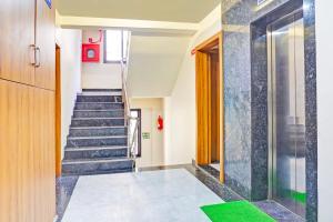a staircase in a building with a green floor at Townhouse Amanora Park Town Formerly Samrat Inn in Pune