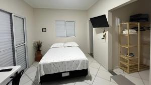a white bedroom with a bed and a window at Kitnet Studio Apartamento Privativo Jundiaí 06 in Jundiaí +9 photos