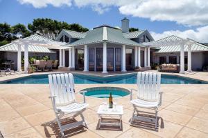 two white chairs and a bottle of wine in a pool at Mango Sunsets in Kawaihae