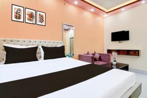 a bedroom with a large bed and a tv at Hotel O Kakdwip in Kākdwīp