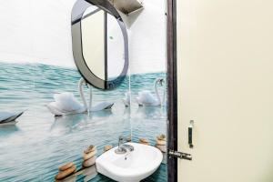 a bathroom with a sink and swans in the water at Hotel O Kakdwip in Kākdwīp