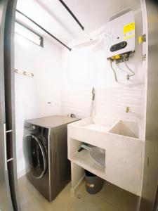 a laundry room with a sink and a washing machine at Santorini Elite in Pereira