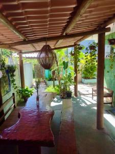 a patio with a table with potted plants and a ceiling at Pousada Maré Alta em Boipeba in Ilha de Boipeba