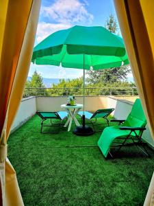 Un patio con una mesa y sillas y una sombrilla. en Апартамент- Студио Кокетно, en Sandanski