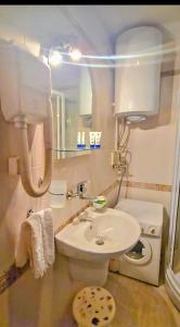 Un baño con un inodoro blanco y un lavabo. en Апартамент- Студио Кокетно, en Sandanski