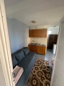 a living room with a blue couch and a kitchen at Villa Imperio in Ulcinj