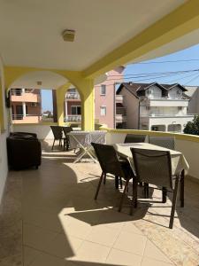 a patio with tables and chairs on a balcony at Villa Imperio in Ulcinj