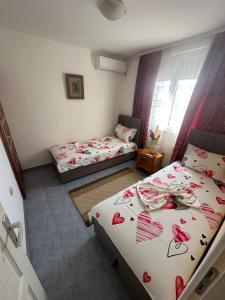 a bedroom with two beds with roses on them at Villa Imperio in Ulcinj