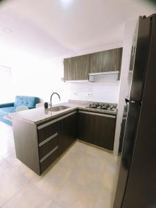 a kitchen with a black refrigerator and a sink at Santorini Elite in Pereira