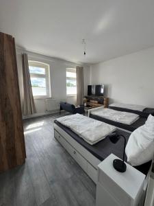 a hotel room with two beds and a television at Seibel's SUITES - Big in Essen - Family & Group in Essen +7 photos