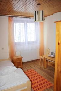 a bedroom with a bed and a table and a window at Noclegi KLARA in Zawoja
