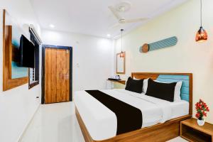 a bedroom with a large bed and a television at Super Townhouse Rajahmundry in Rājahmundry