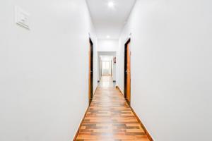 a hallway with a wooden floor and white walls at Super Townhouse Rajahmundry in Rājahmundry