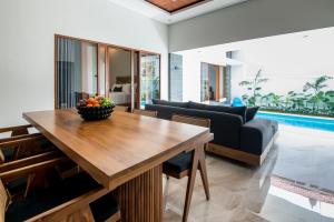 a living room with a wooden table and a couch at Villa Sakura ll seminyak in Seminyak