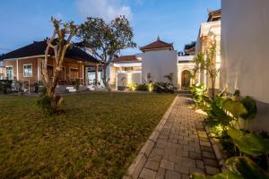 a house with a lawn in front of it at Villa Sakura ll seminyak in Seminyak