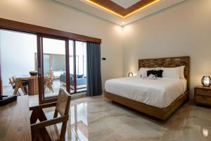 a bedroom with a bed and a desk with a chair at Villa Sakura ll seminyak in Seminyak +17 photos