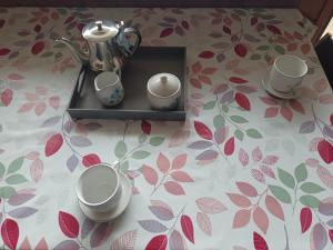 ein Teekessel und Tassen auf einem Tisch in der Unterkunft studio aux pieds des pistes in Besse-et-Saint-Anastaise + 22 Fotos