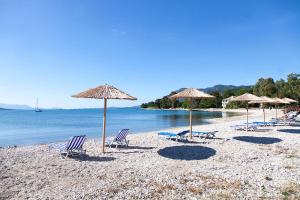 un groupe de chaises et de parasols sur une plage dans l'établissement Faros Studios, à Lygia