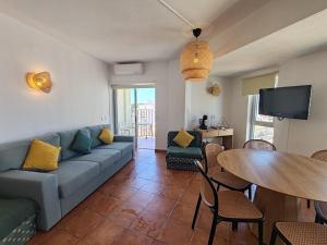 a living room with a couch and a table at 11A Rocha - Casas & Papeis in Armação de Pêra
