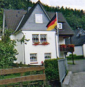 ein Haus mit einer Flagge davor in der Unterkunft Pension Deimel in Hallenberg