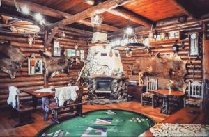 a log cabin living room with a table and a fireplace at Karczma Starożyn in Płaska