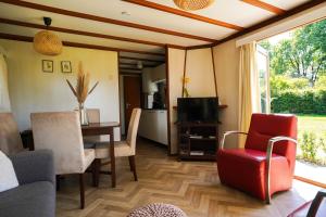 a living room with a table and chairs and a television at Zwartbles in Elspeet