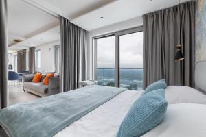 a bedroom with a large bed with a large window at Balticus by Solarento in Międzyzdroje