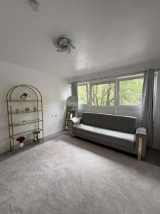 a living room with a couch and a window at Newly Refurbished - Stylish - Modern - And Cosy Flat - King Size Bed with Built In Speakers - Bedside Lamp - And USB Ports - Sofa Bed - In Islington North London in London