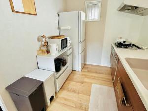 a kitchen with a white refrigerator and a microwave at VJ House in Fukuoka +40 photos