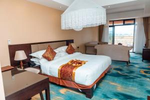 a hotel room with a large bed and a desk at Hotel Triangle Mbarara in Mbarara +33 photos