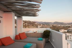 a couch on a balcony with a view of a city at HIGH END Unique 270 degree aerial sea view suite in Naxos Chora