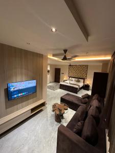 a living room with a couch and a flat screen tv at Woods N Wilds in Virajpet