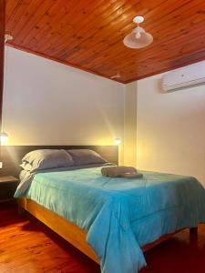 a bedroom with a large bed with a wooden ceiling at Mandua in Puerto Iguazú