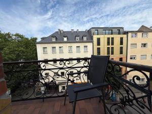 a chair sitting on a balcony with a building at Schönes Apartment in der nähe vom Hauptbahnhof in Koblenz +14 photos