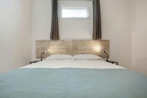 a white bed with two pillows and a window at La Lajita Beach House in La Lajita