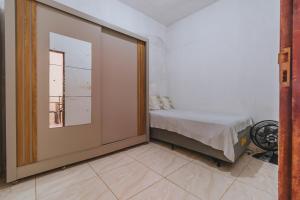 a room with a bed and a door with a window at Doce Lar 58- Quarto Exclusivo in Cabo de Santo Agostinho