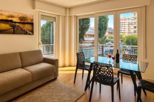a living room with a couch and a table and chairs at Fontana apartment in Lignano Sabbiadoro