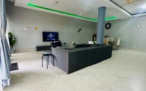 a large living room with a couch and a tv at Jessica's Villa in Accra +9 photos