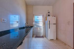 a kitchen with a white refrigerator and a staircase at Doce Lar 58- Quarto Exclusivo in Cabo de Santo Agostinho